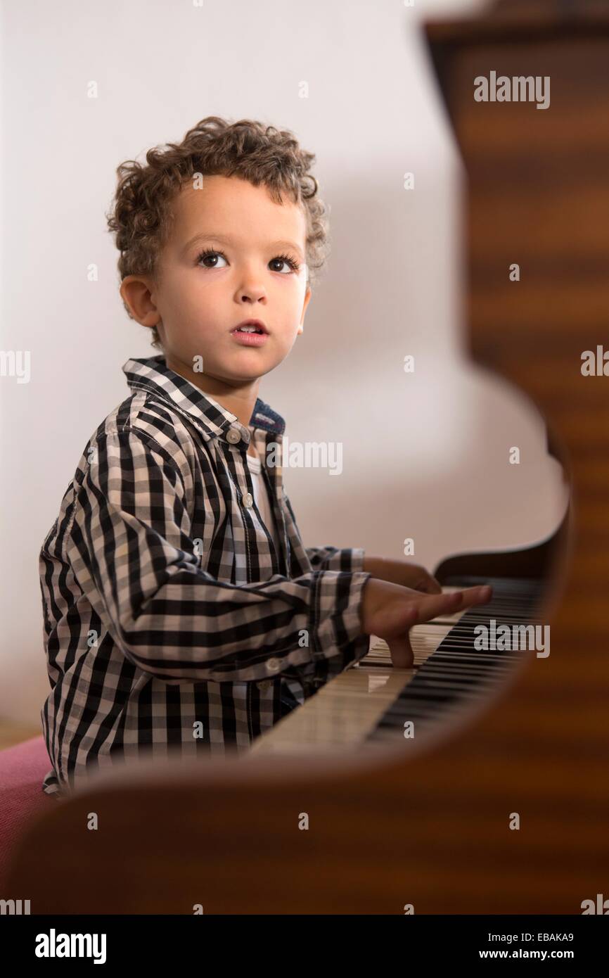 Four year old boy playing the piano Stock Photo Alamy