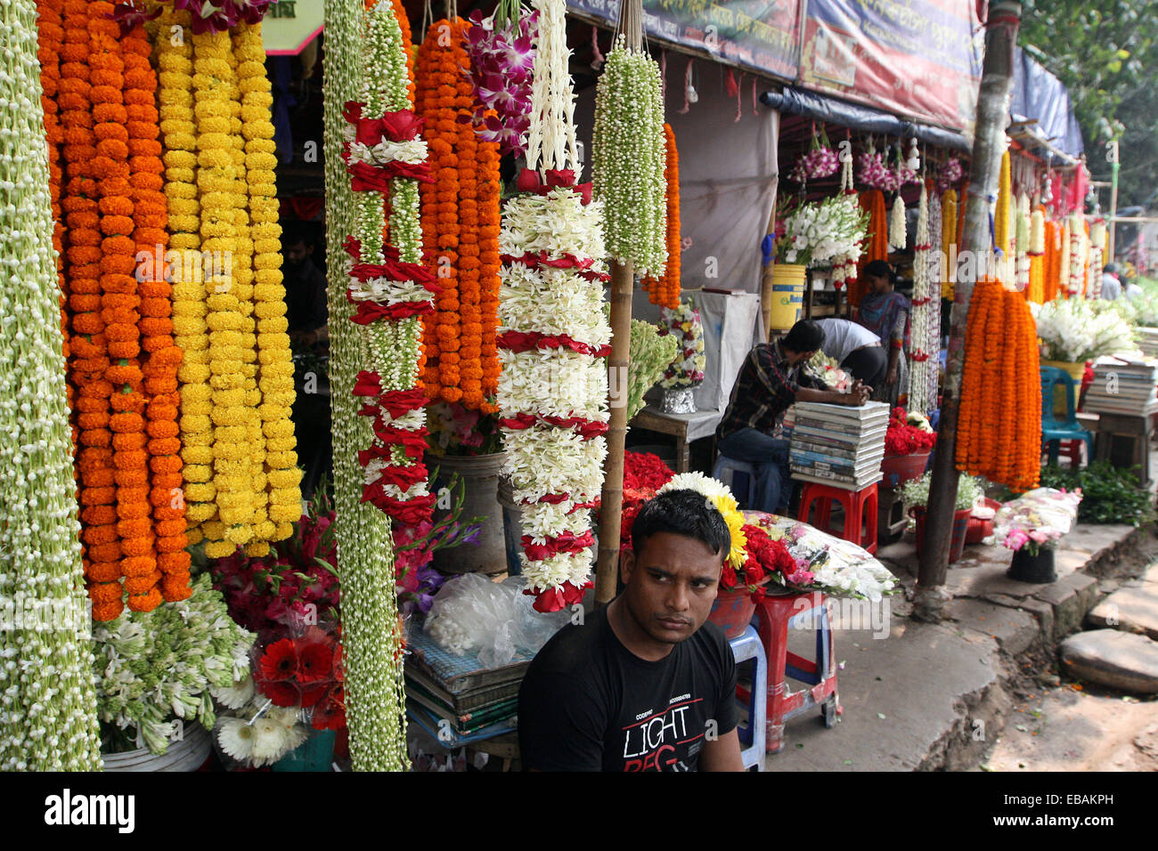 November 2014. Flower vendor at his stall in the flower market in Dhaka Bangladesh Stock Photo