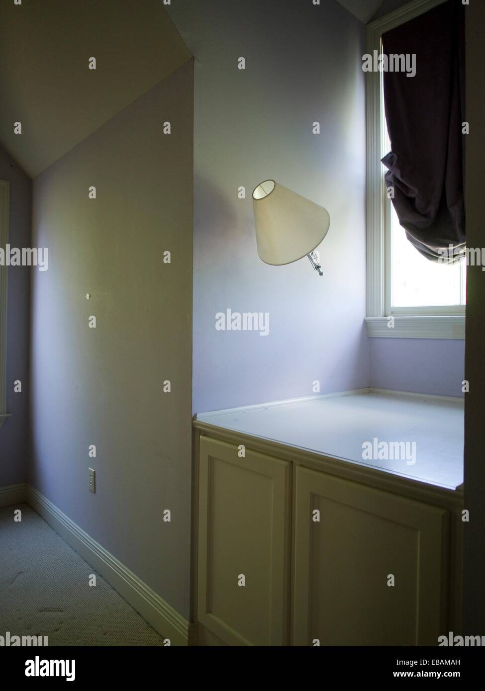 A lamp tilts to the side, hanging askew inside a foreclosed home in