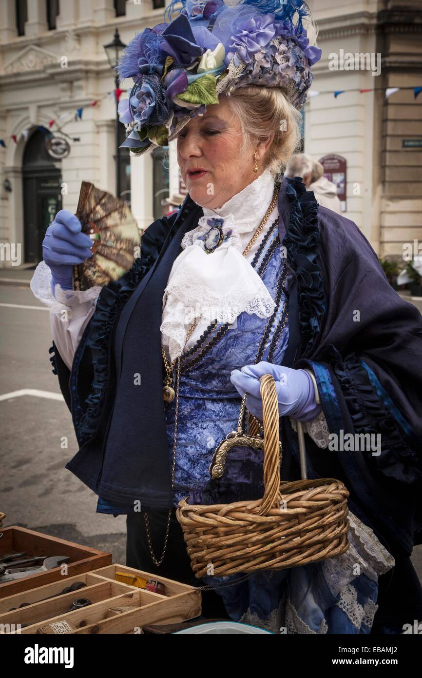 Lady in Victorian dress is delighted to find old fan in market stall Victorian festival historic precinct Oamaru Otago Stock Photo