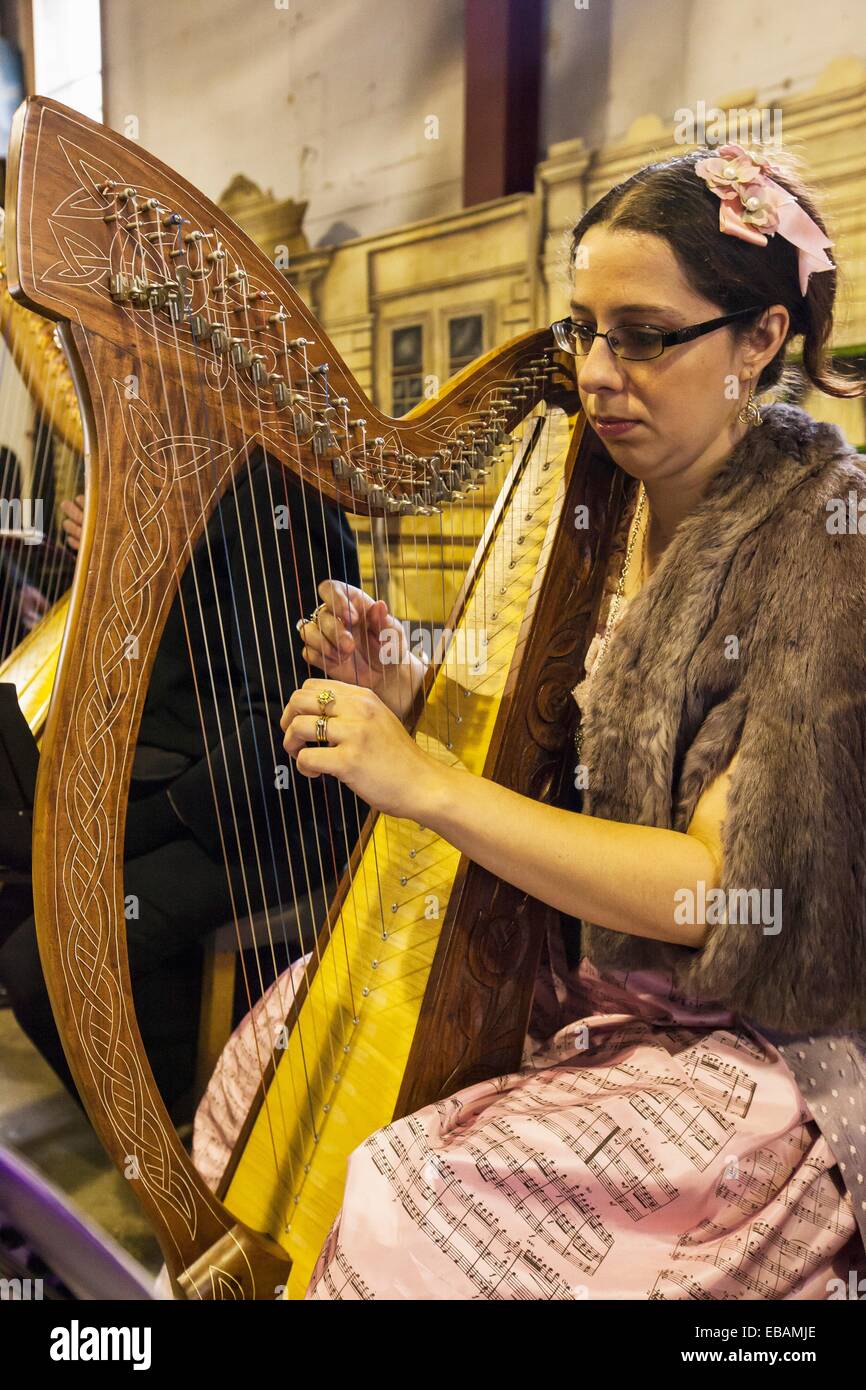 Lady plays harp, dressed in Victorian costume, Victorian festival, historic precinct, Oamaru, Otago Stock Photo