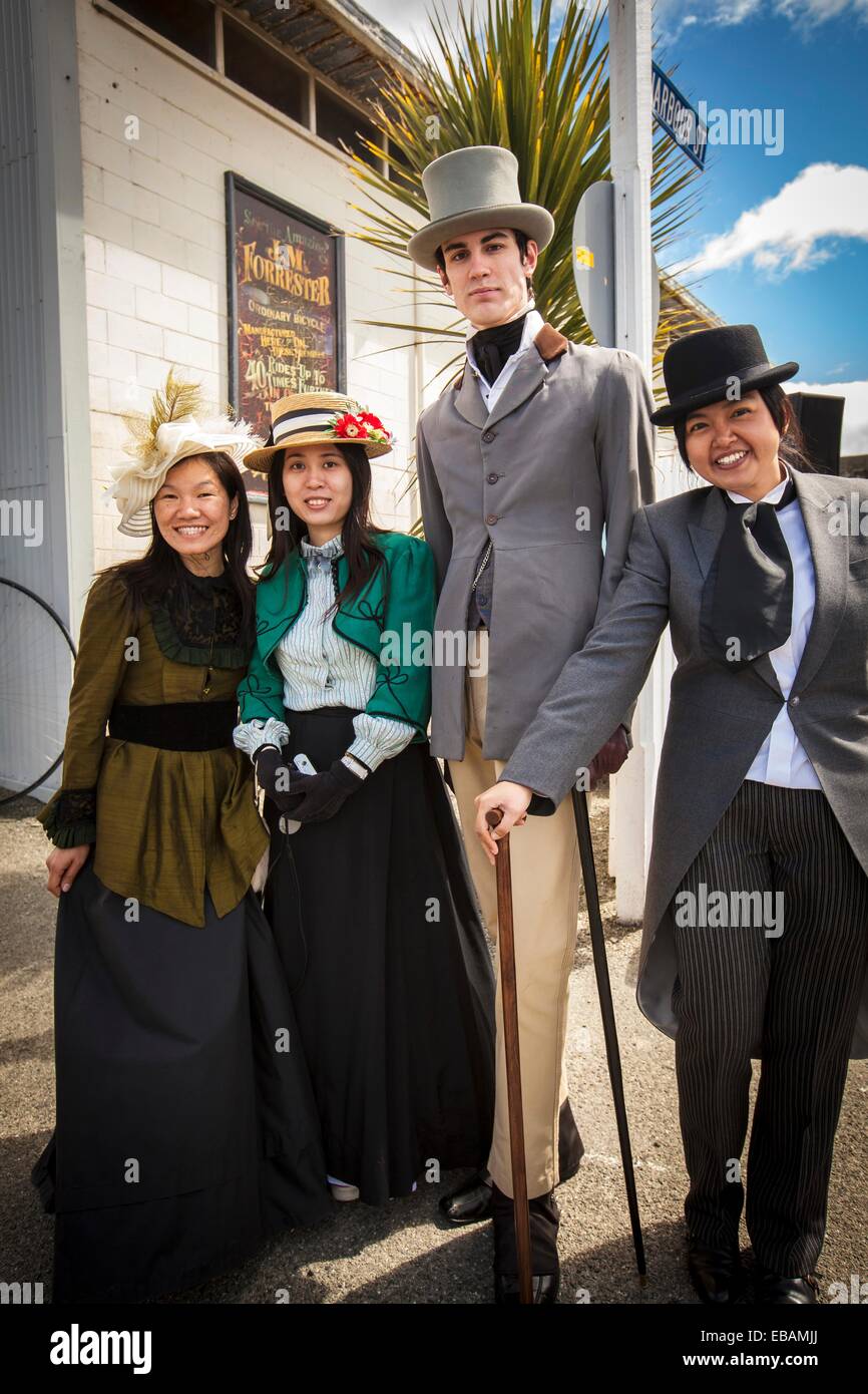 Asian students in Victorian dress meet tall gentleman Victorian festival historic precinct Oamaru Otago Stock Photo