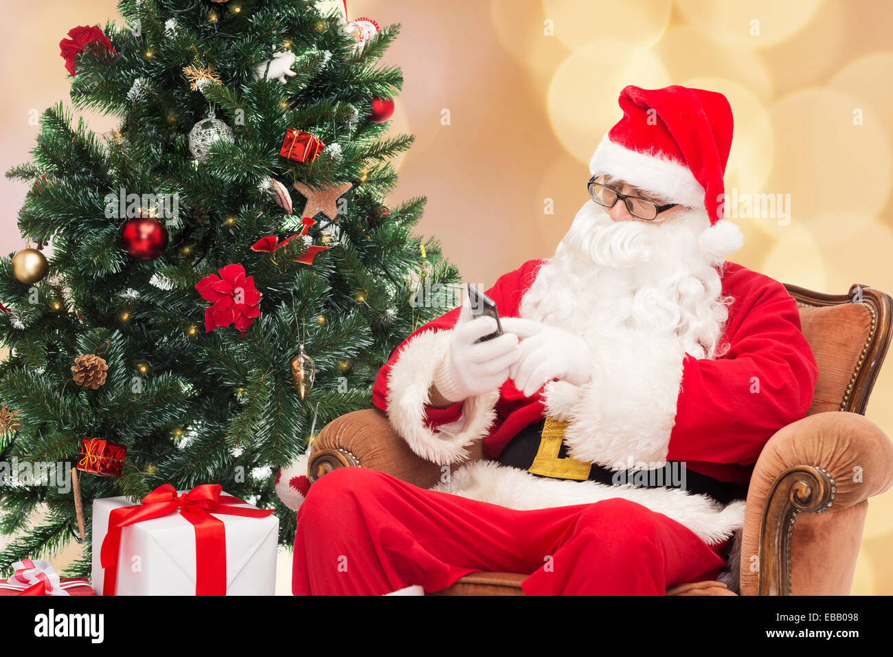santa claus with smartphone and christmas tree Stock Photo - Alamy