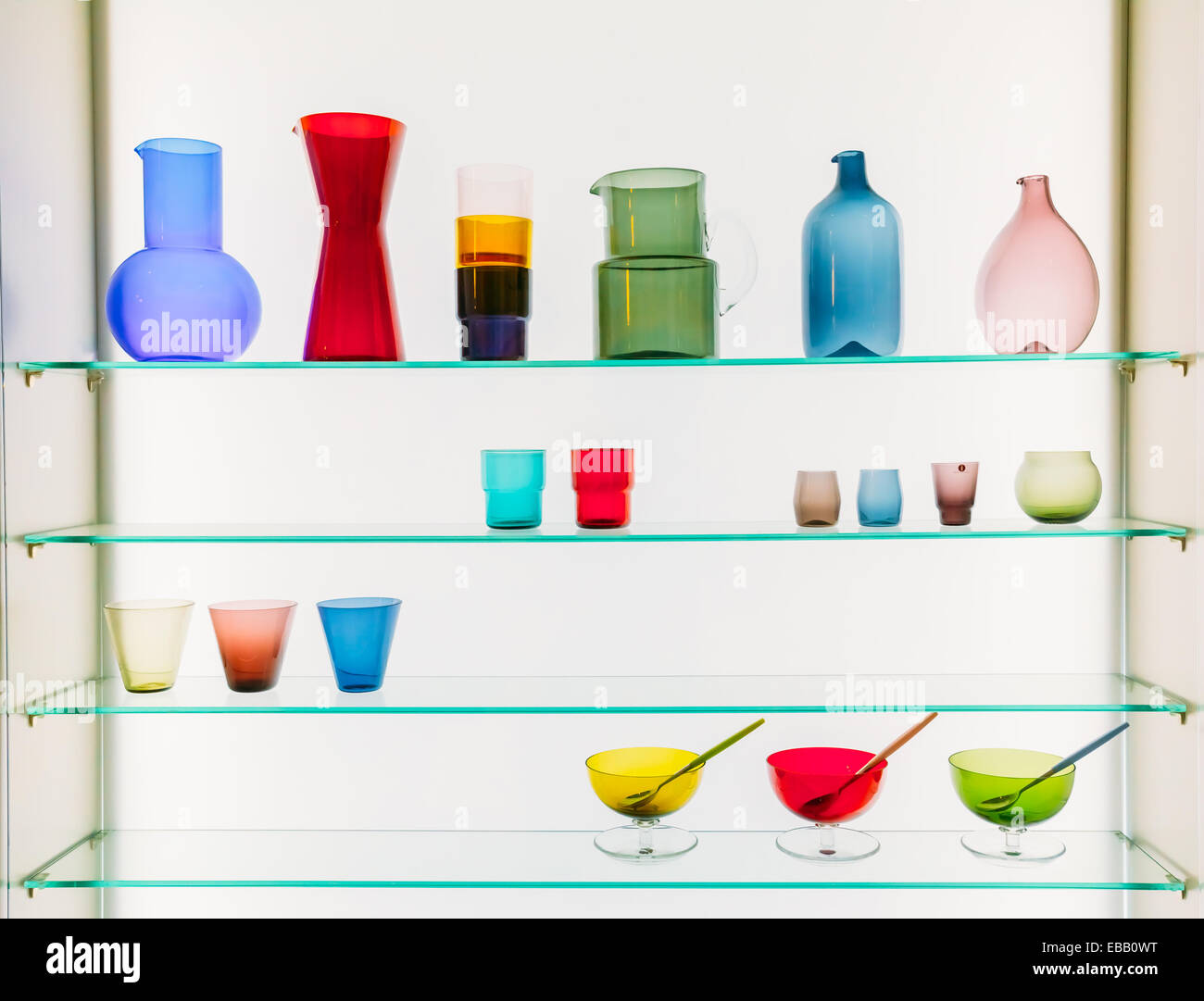 Assorted Different Sizes And Shapes Of Colorful Glassware On Shelves. Vases, Pitchers, Jugs, Glasses On White Background. Stock Photo