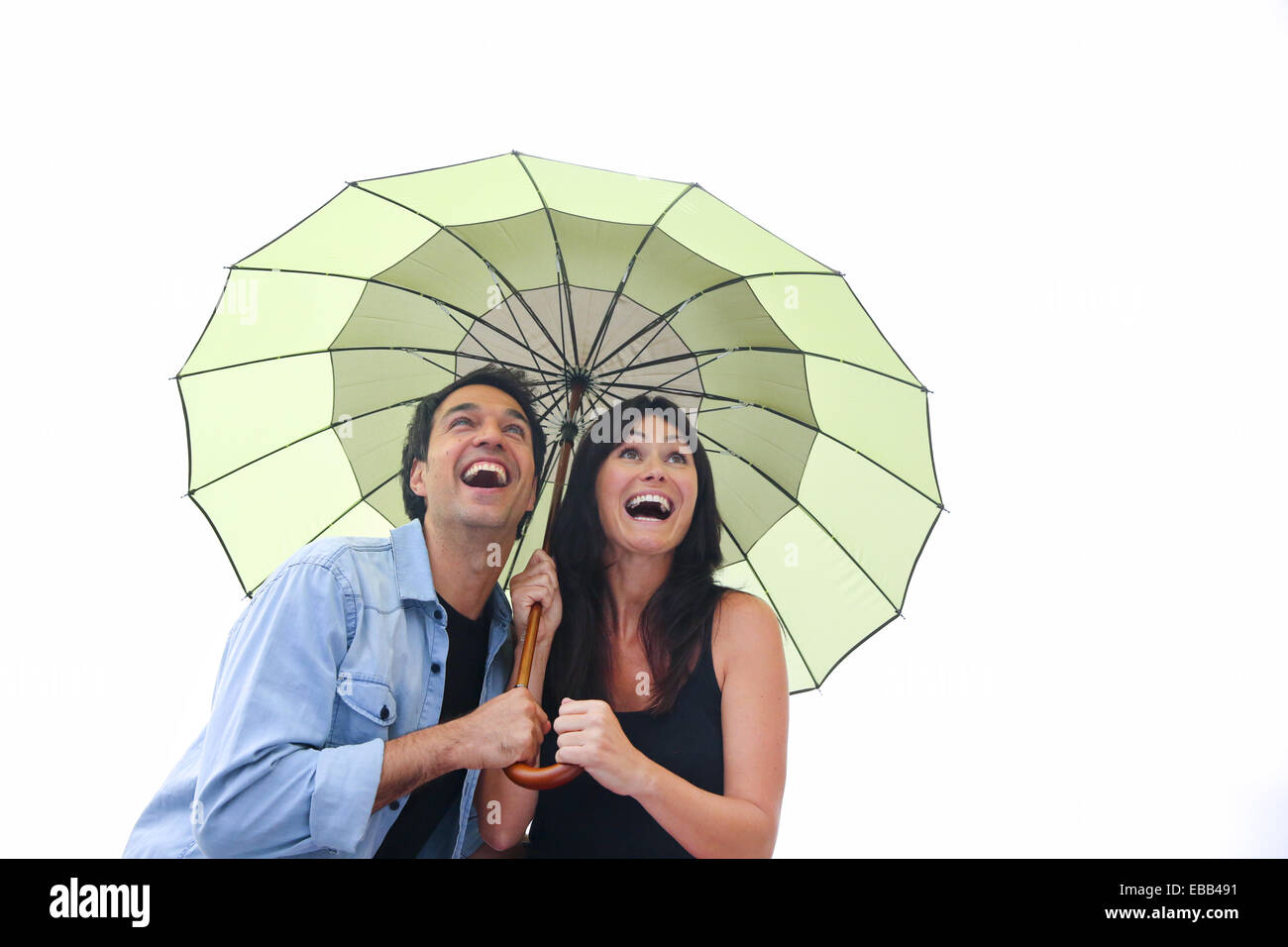 Couple in their 30´s smiling under umbrella. Stock Photo