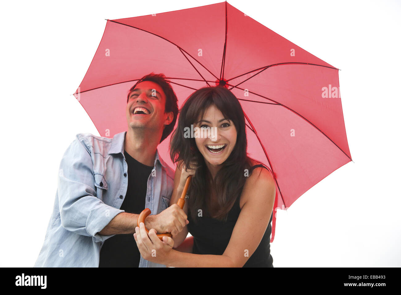 Couple in their 30´s smiling under umbrella. Stock Photo