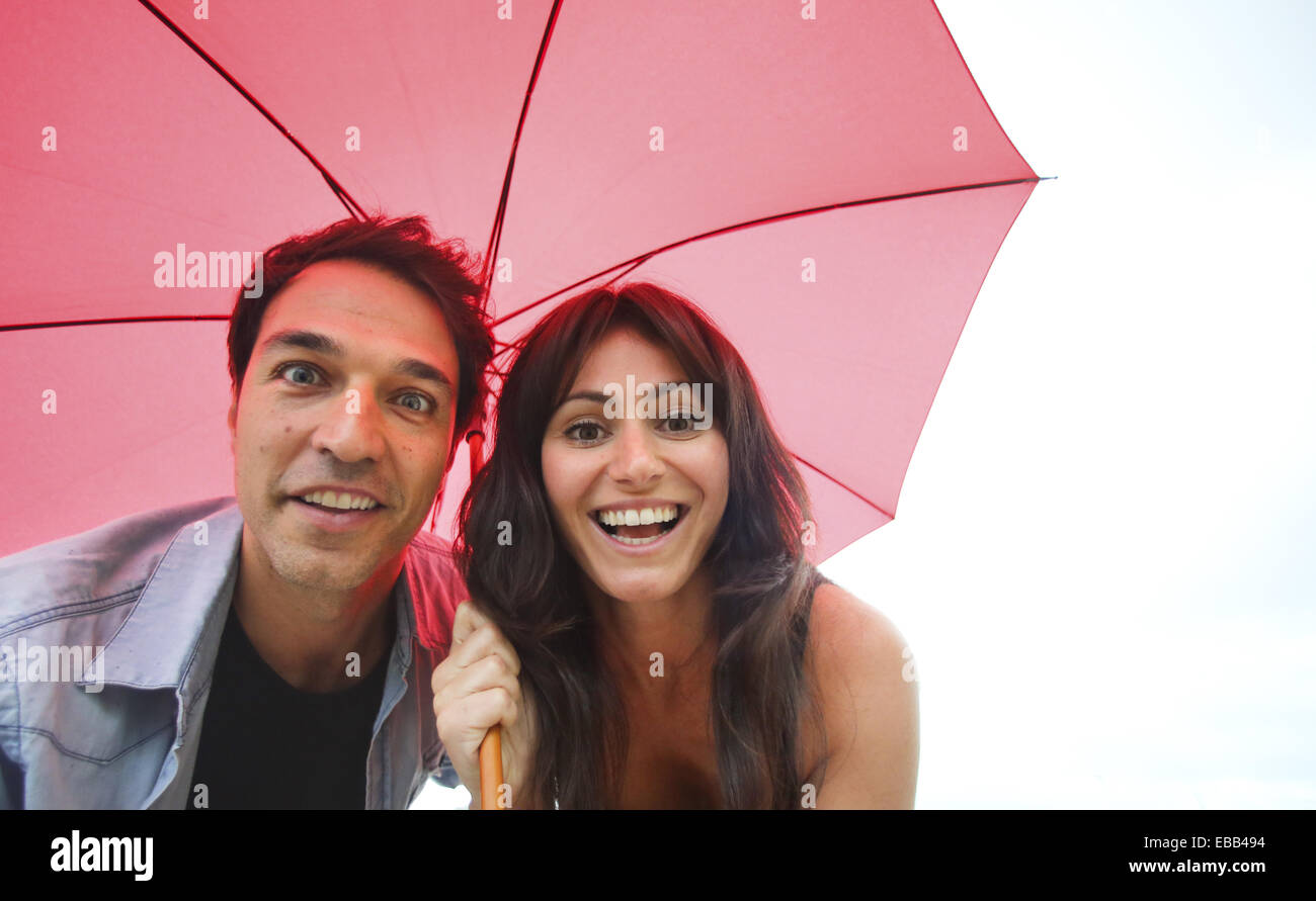 Couple in their 30´s smiling under umbrella Stock Photo - Alamy