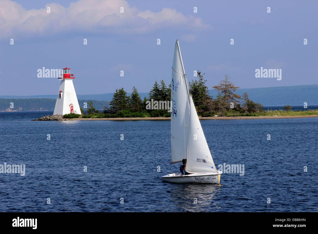 Canada Nova Scotia Cape Breton Baddeck Bras d´Or Lake lighthouse with sloop sail boat Stock