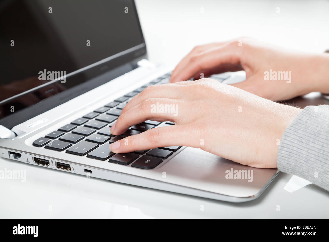 woman using laptop on white desk Stock Photo