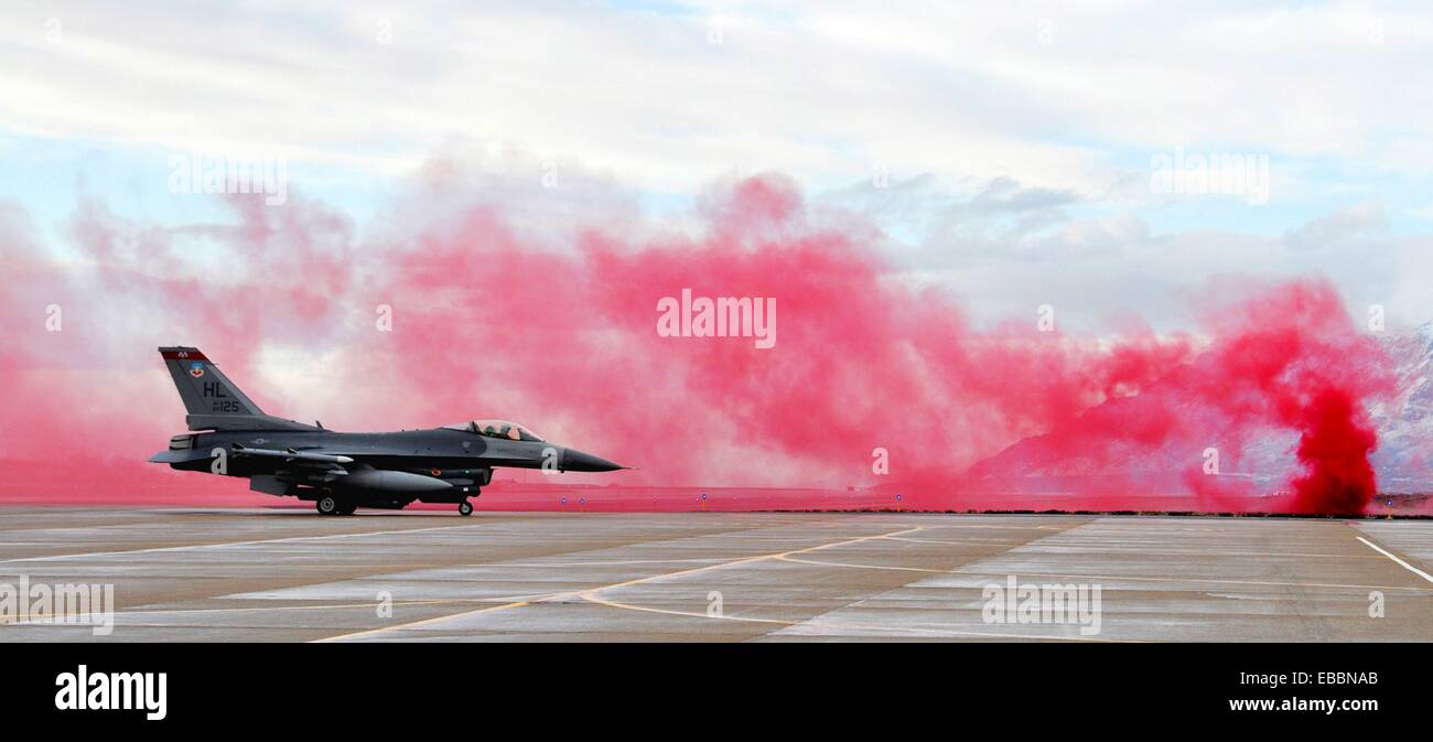 An F-16 Fighting Falcon from the 388th Fighter Wing taxis through red smoke from an ´attack´ during an operational readiness Stock Photo