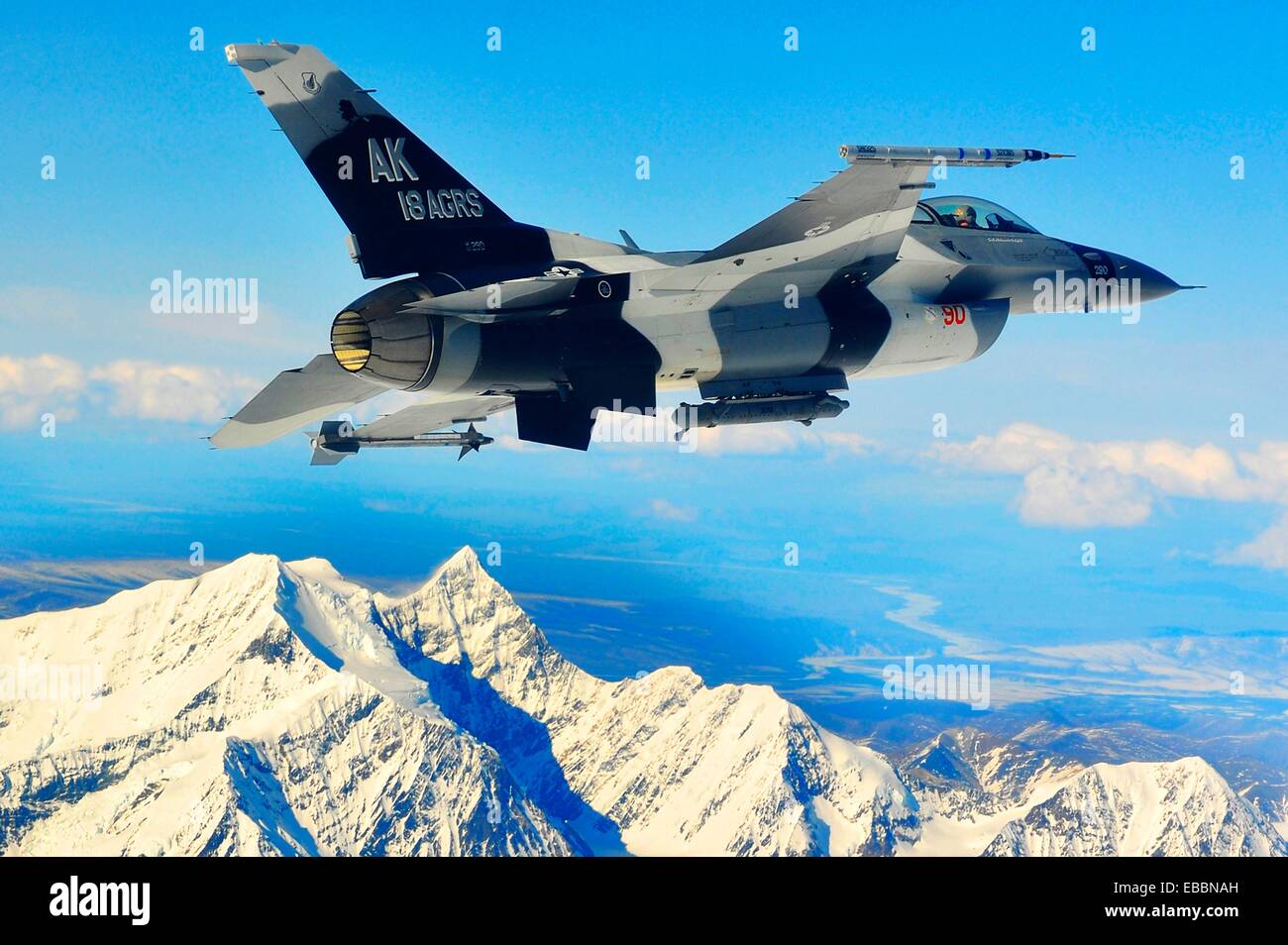 An F-16 Fighting Falcon from the 18th Aggressor Squadron at Eielson Air Force Base, Alaska, soars over the Alaska Range April Stock Photo