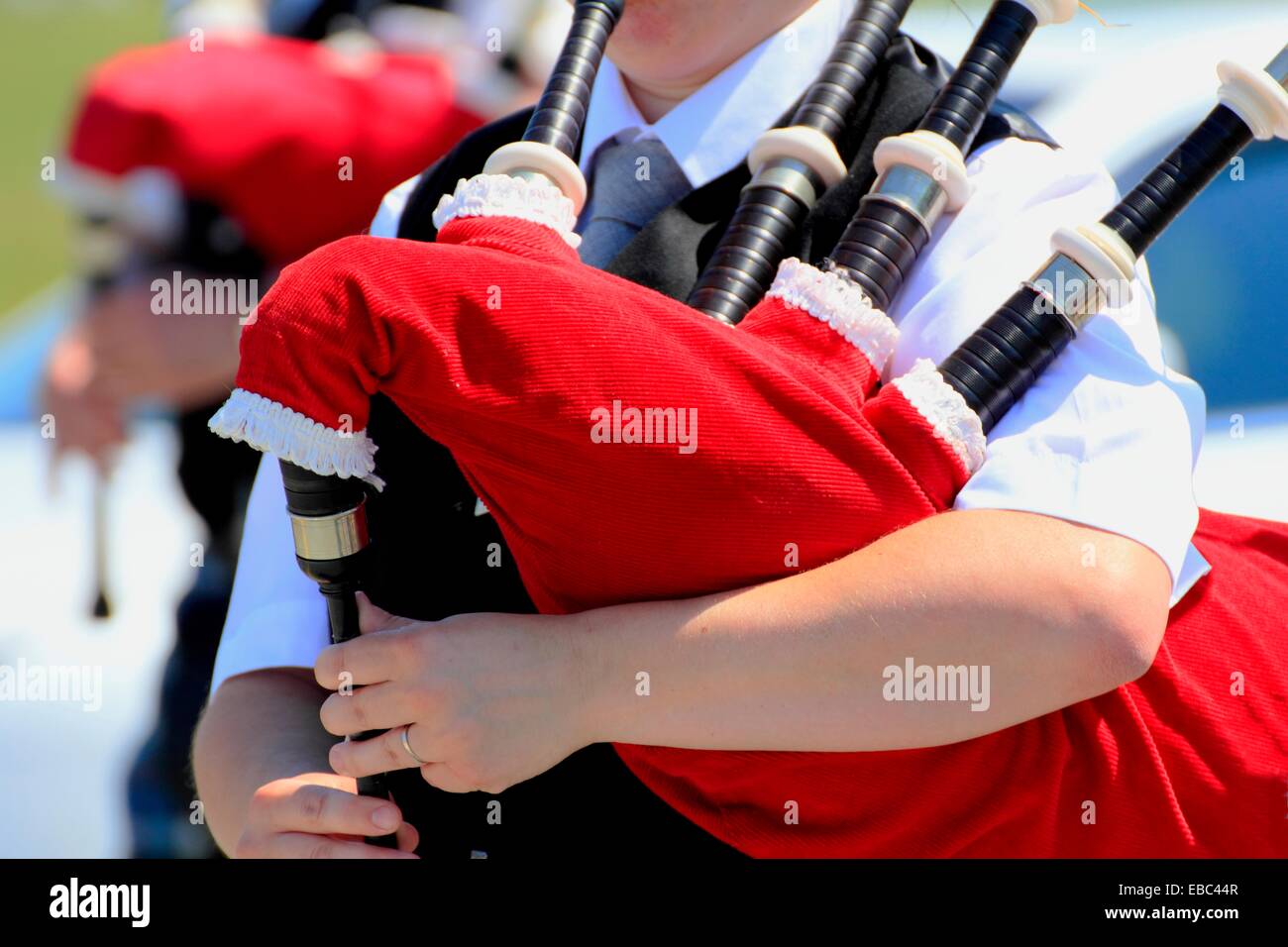 A bagpiper playing the bagpipe marching in a scottish bagpipe band in a