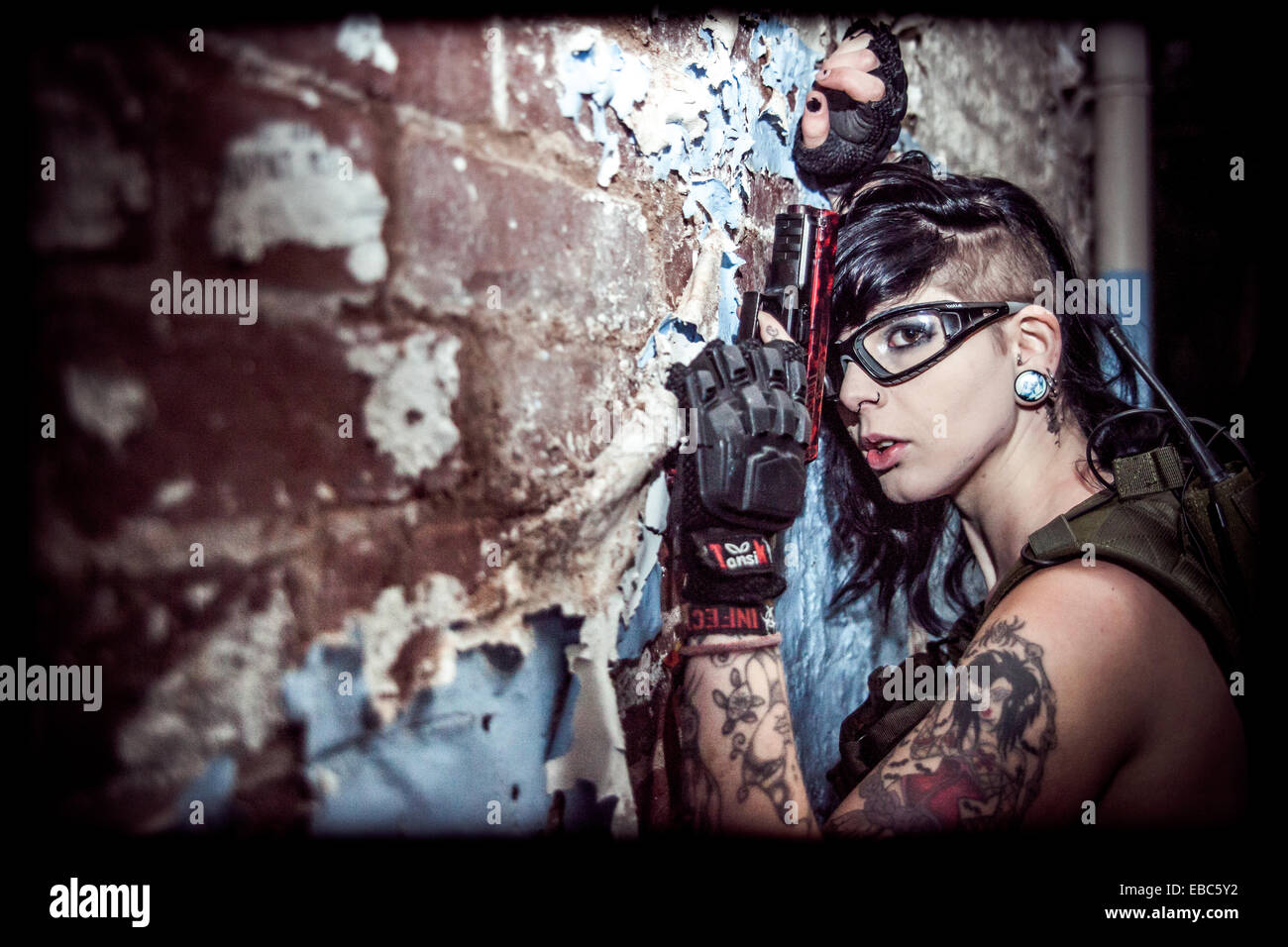 A young female dressed in protective safety clothing for airsoft games