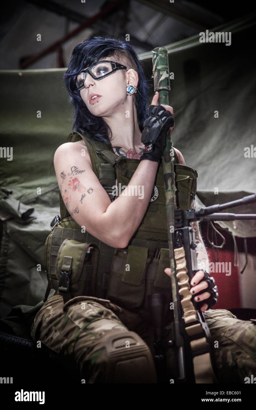 A young female dressed in protective safety clothing for airsoft games with her military style gun. Stock Photo