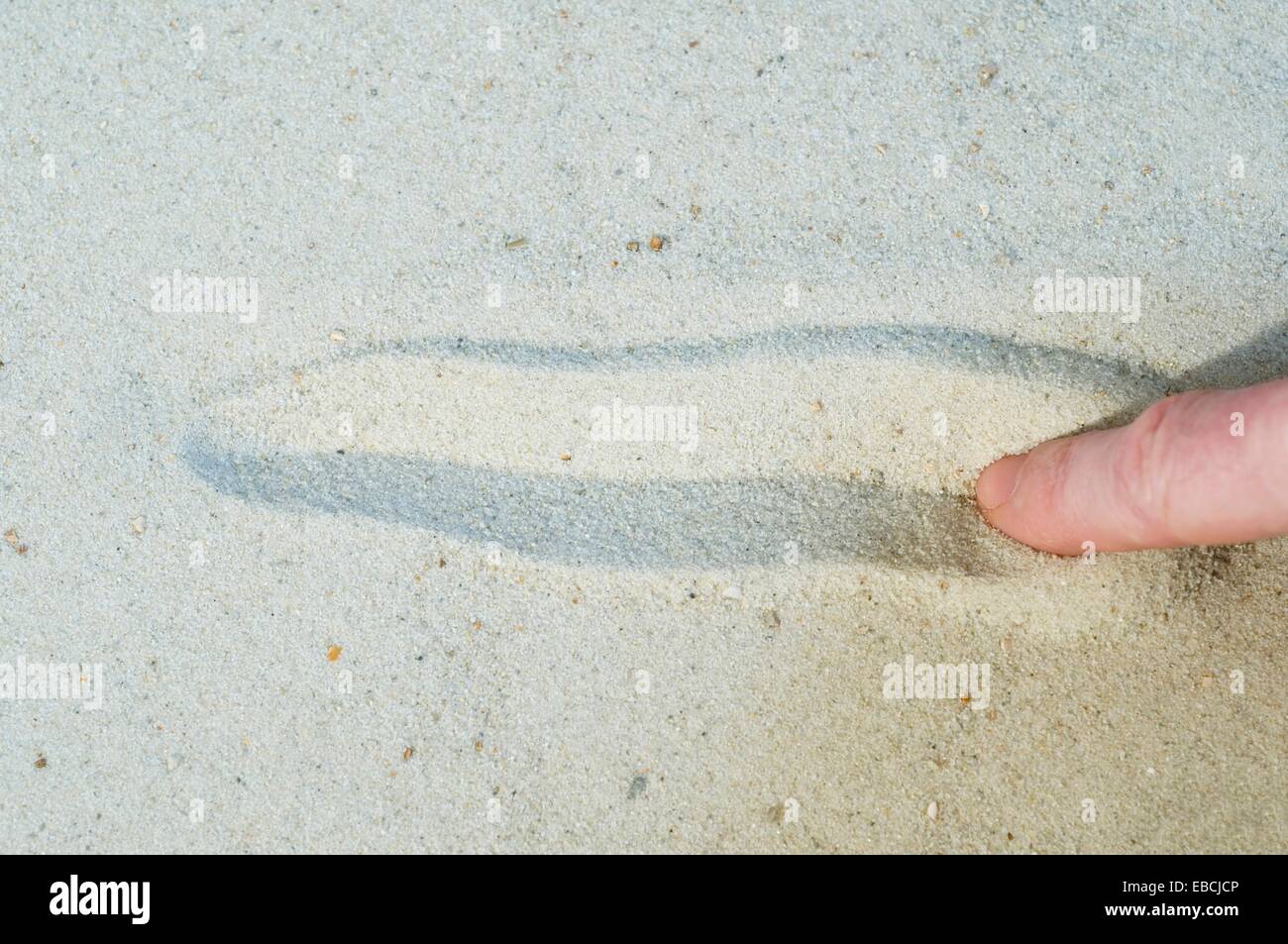 finger tracing line on sand Stock Photo Alamy