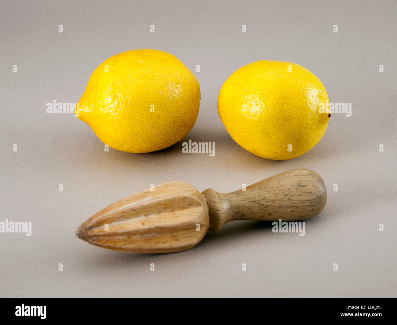 Two lemons with wooden juice extractor Stock Photo Alamy
