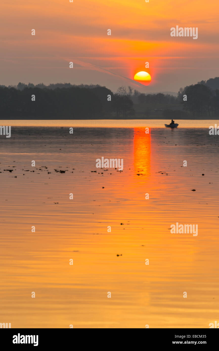 fisherman in boat on lake at sunset Stock Photo - Alamy