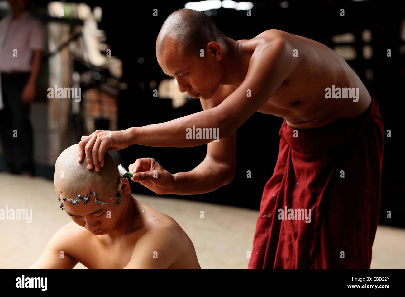 Monk shaving head of novice prior to entering the monastery ...