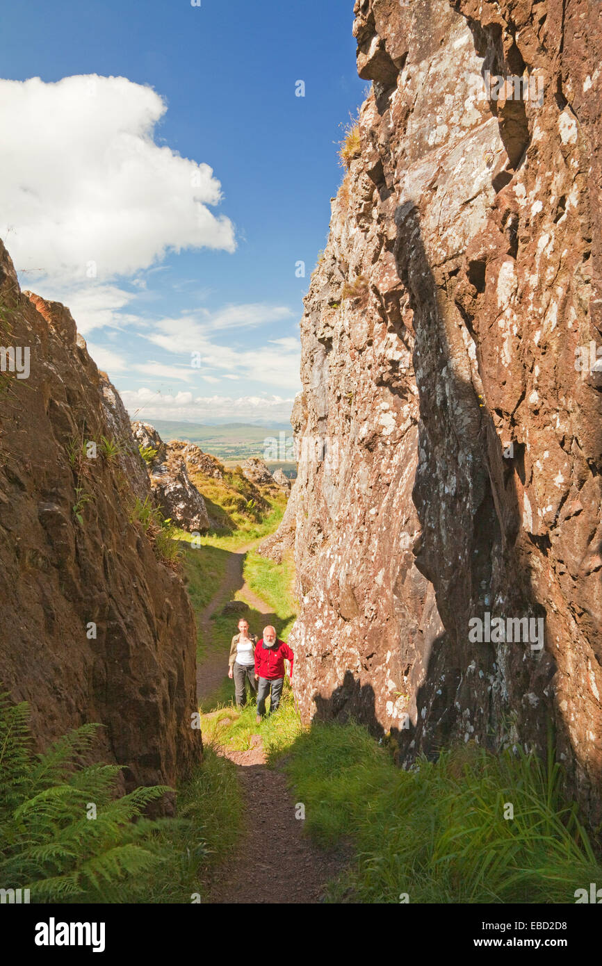 Two walkers in the Whangie rock feature in the Kilpatrick Hills near Glasgow Stock Photo