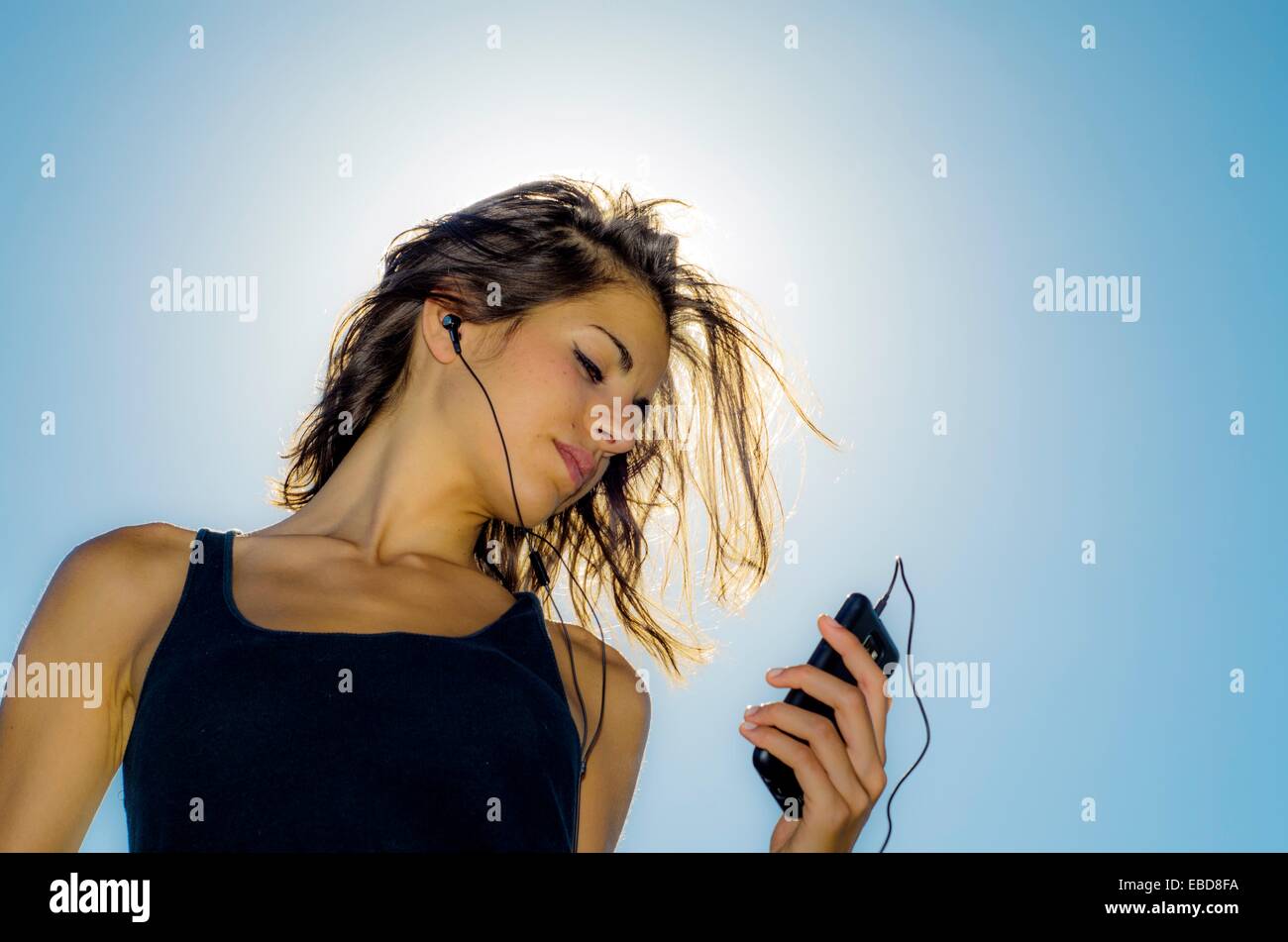 From above of young female with short blue hair and in trendy futuristic  dress listening to music with phone on street steps Stock Photo - Alamy