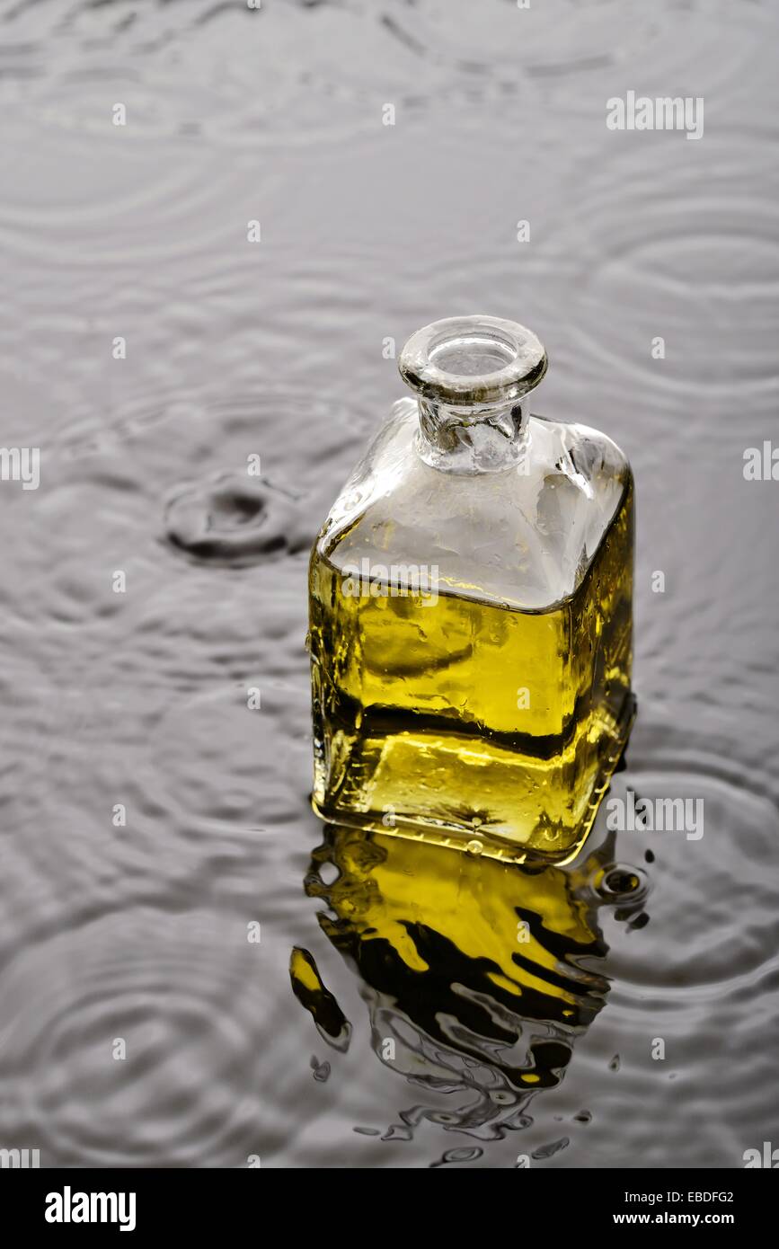 bañera Joseph Banks estornudar Líquido amarillo, aceite o perfume, en un frasco de vidrio sobre el agua  con gotas de agua y ondas Stock Photo - Alamy