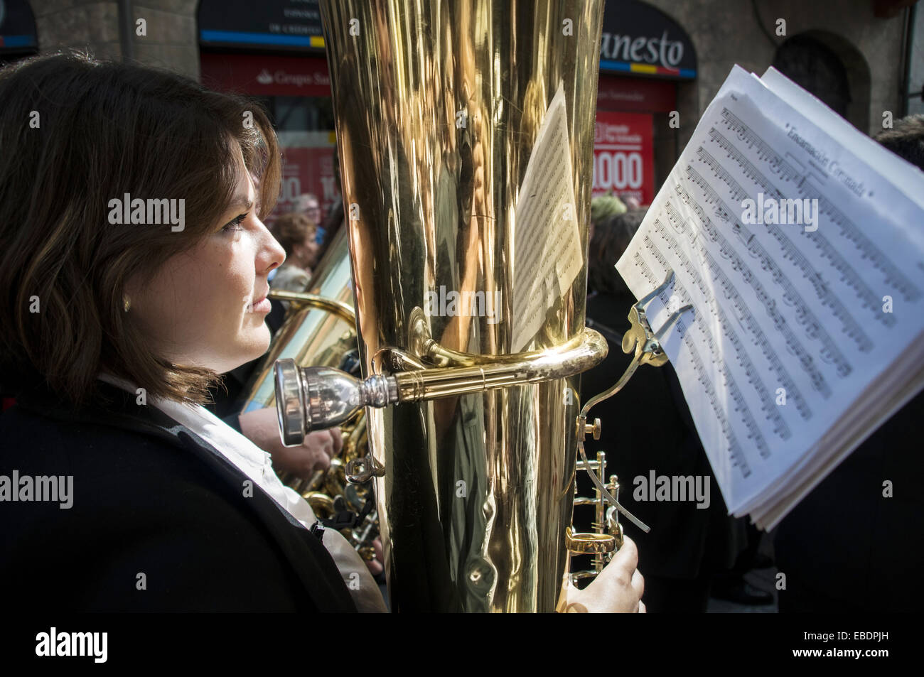 A woman playing the tuba in the marching band during a parade through