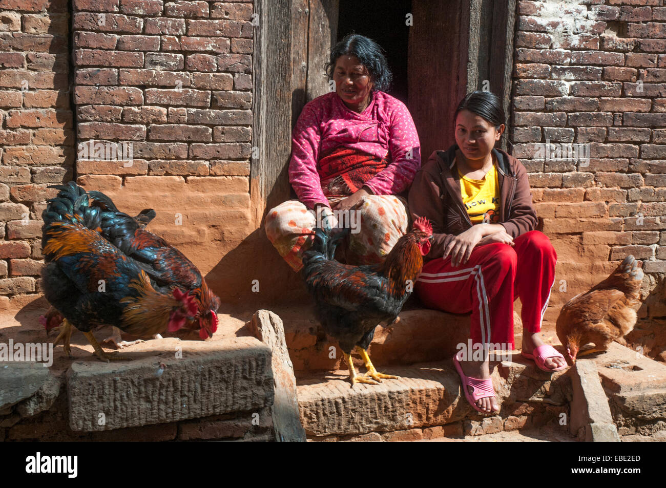 Mother and daughter on their doorstep in Bhaktapur, Kathmandu Valley, Nepal Stock Photo