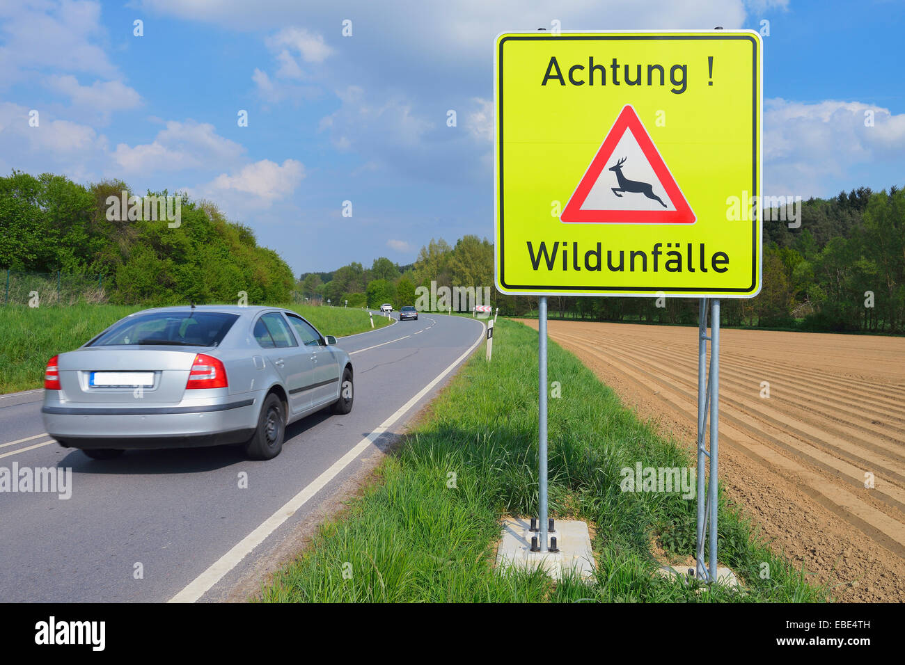 Car Passing Deer Crossing Sign, Odenwald, Hesse, Germany Stock Photo