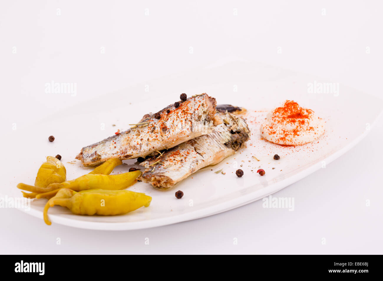 Fish, peppers  and cream on white plate. Stock Photo