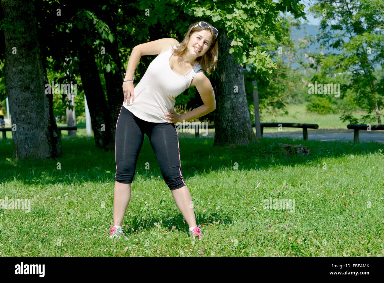 sporty young woman makes stretching exercises on grass Stock Photo - Alamy