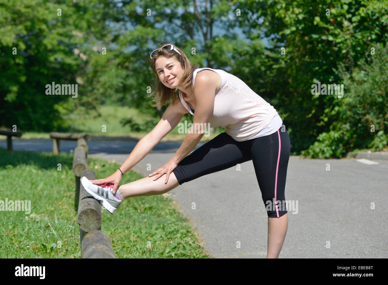 sporty young woman makes stretching exercises on grass Stock Photo - Alamy