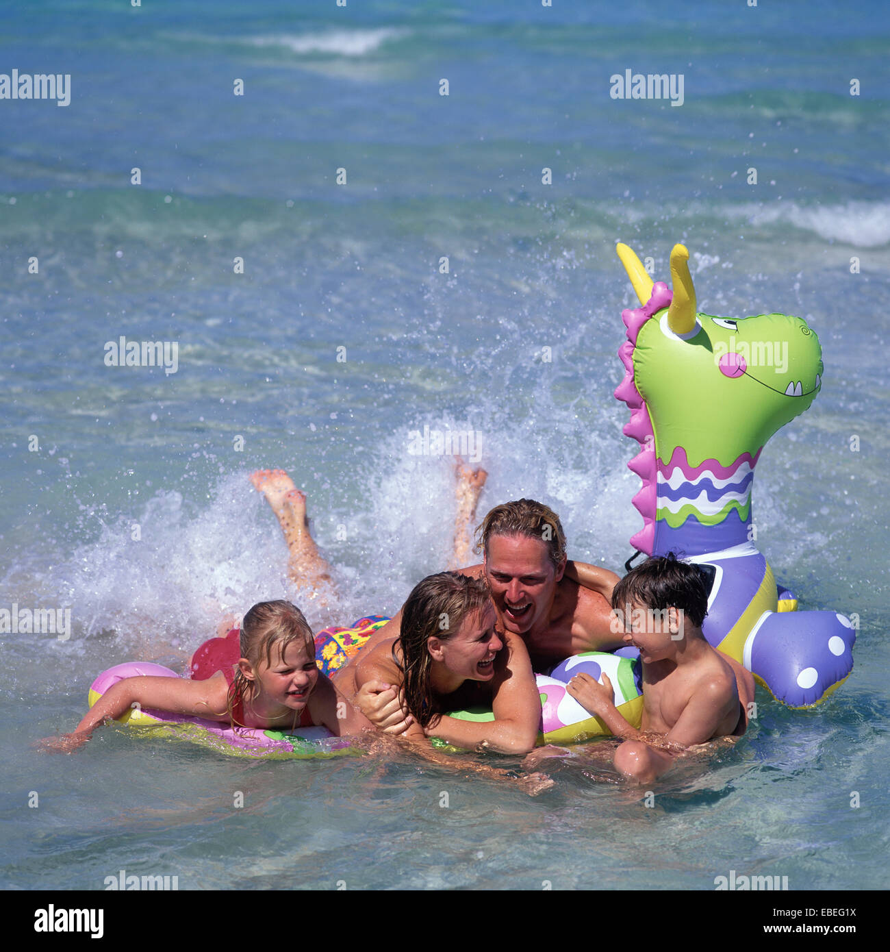 FAMILY IN SEA WITH BEACH TOY Stock Photo