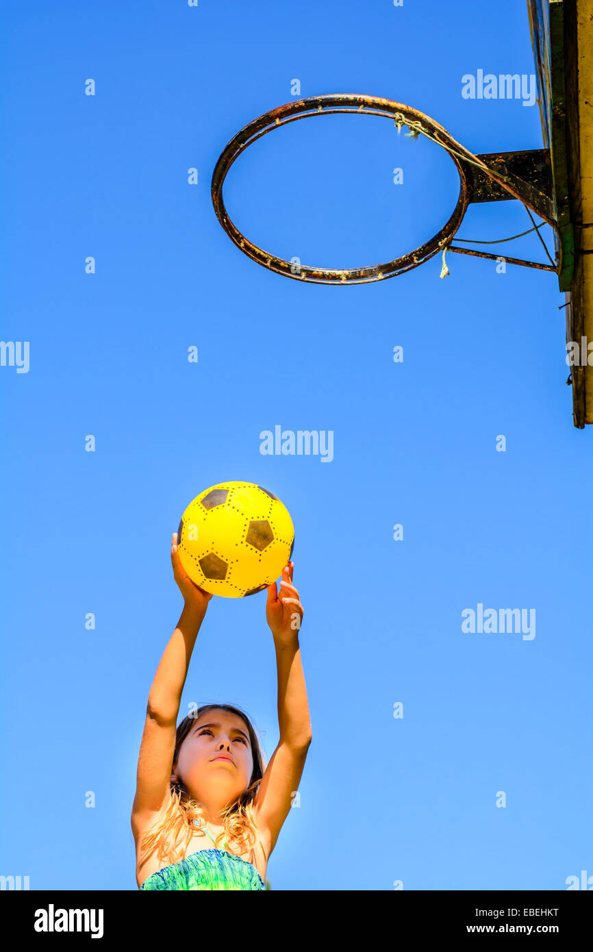 Seven year old girl playing basketball Stock Photo