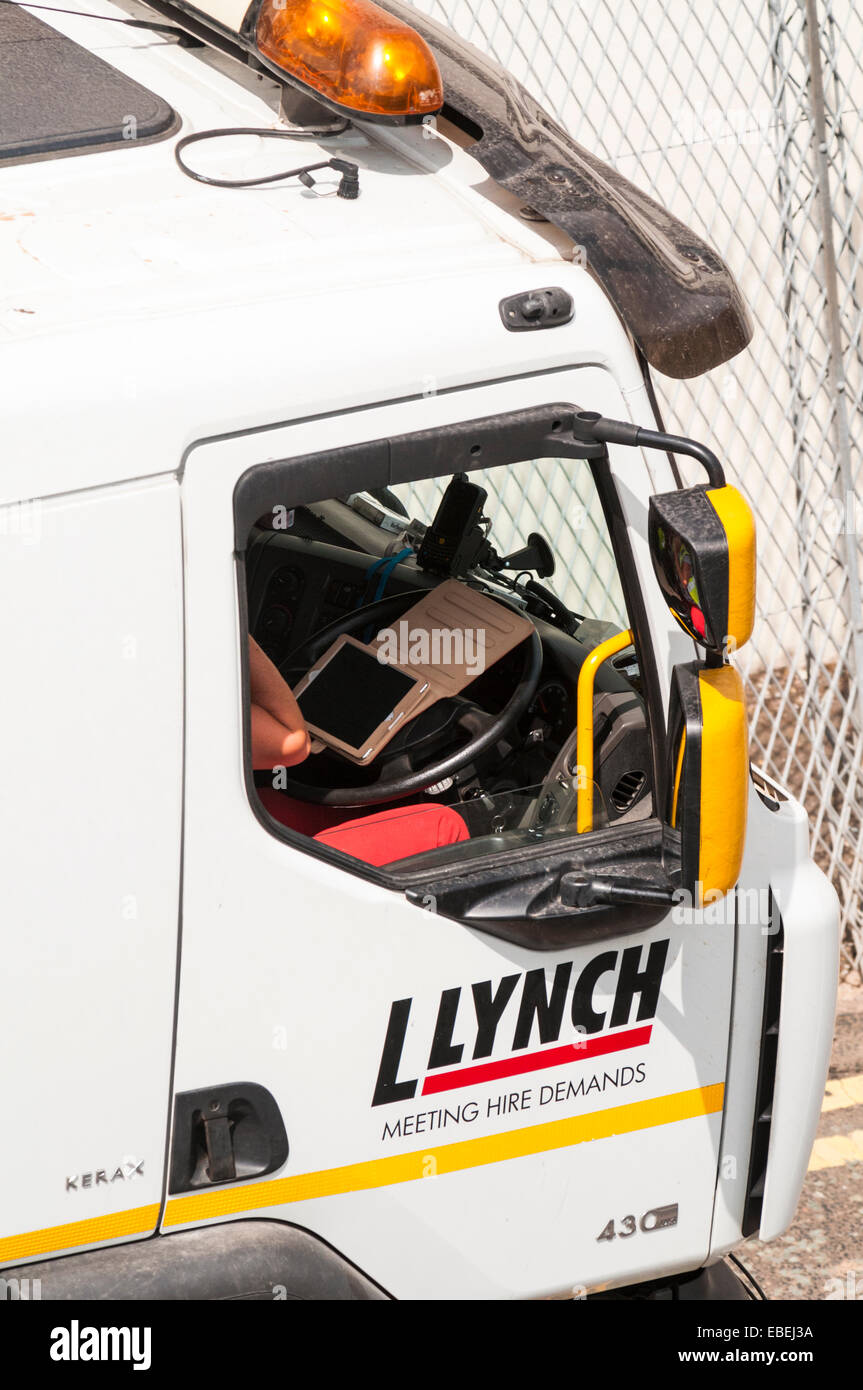 Looking down onto the driving cab of a lorry as the driver checks his schedule on a tablet device Stock Photo