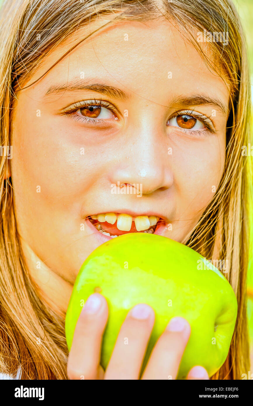 Beautiful nine year old girl  eating apple Stock Photo