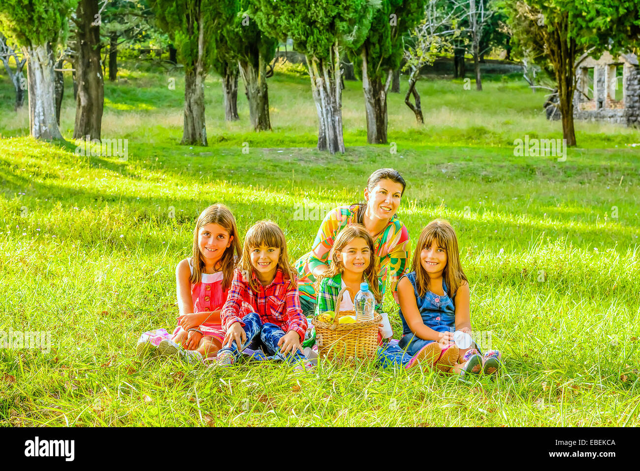 Mother and four little girls having picnic in the park Stock Photo