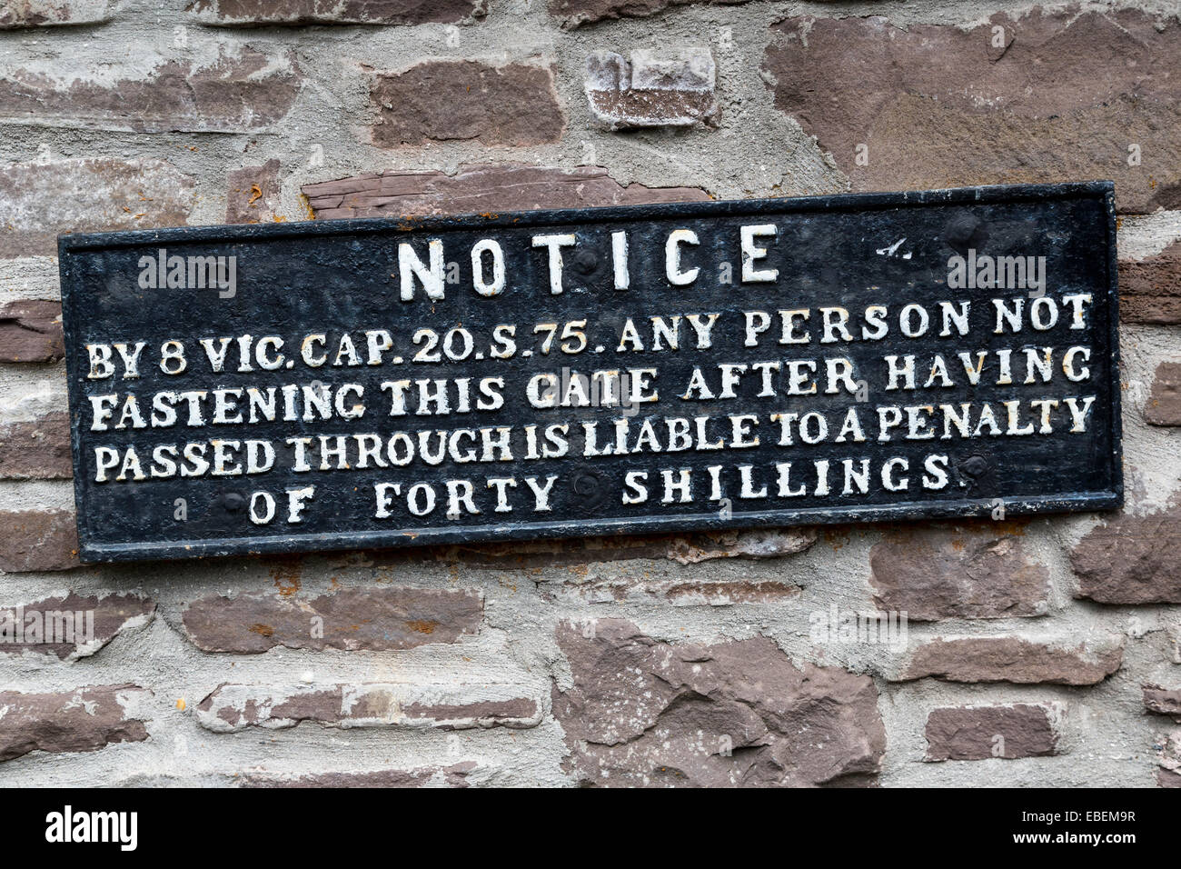 Old notice in cast iron warning of fine if gate left open, Wales, UK Stock Photo