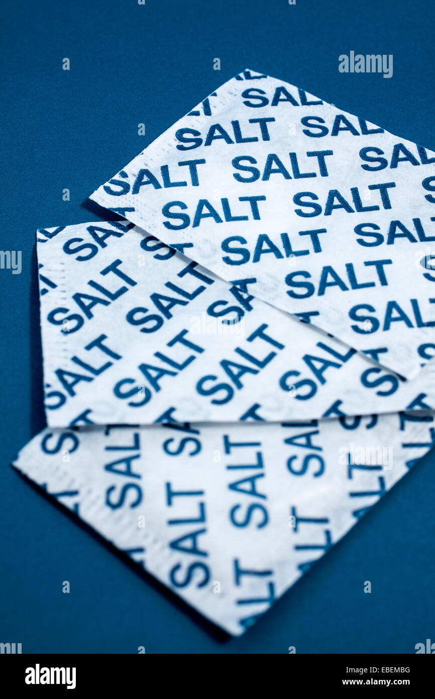 Salt sachets on a blue background Stock Photo - Alamy