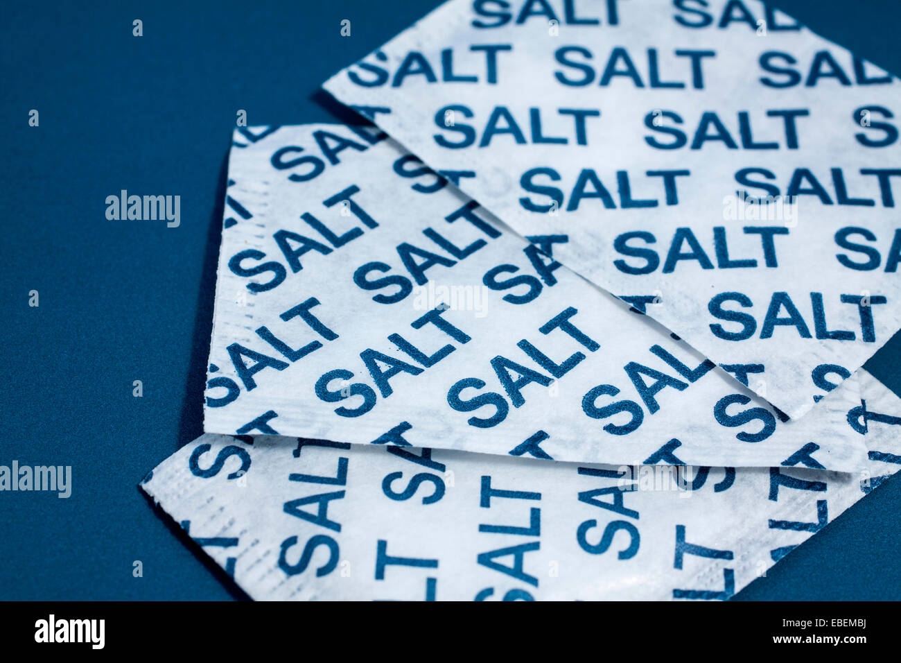 Salt sachets on a blue background Stock Photo - Alamy