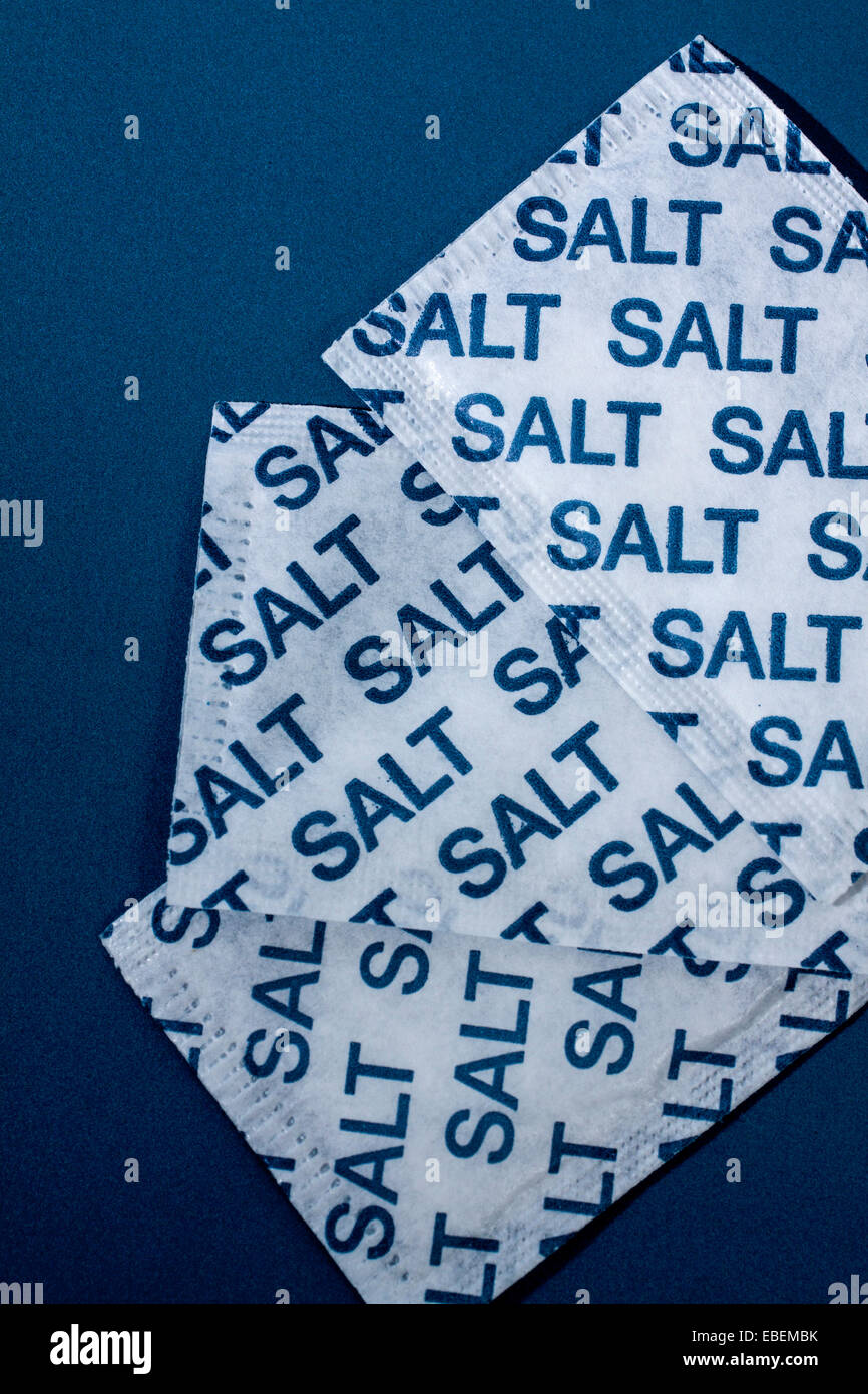Salt sachets on a blue background Stock Photo - Alamy