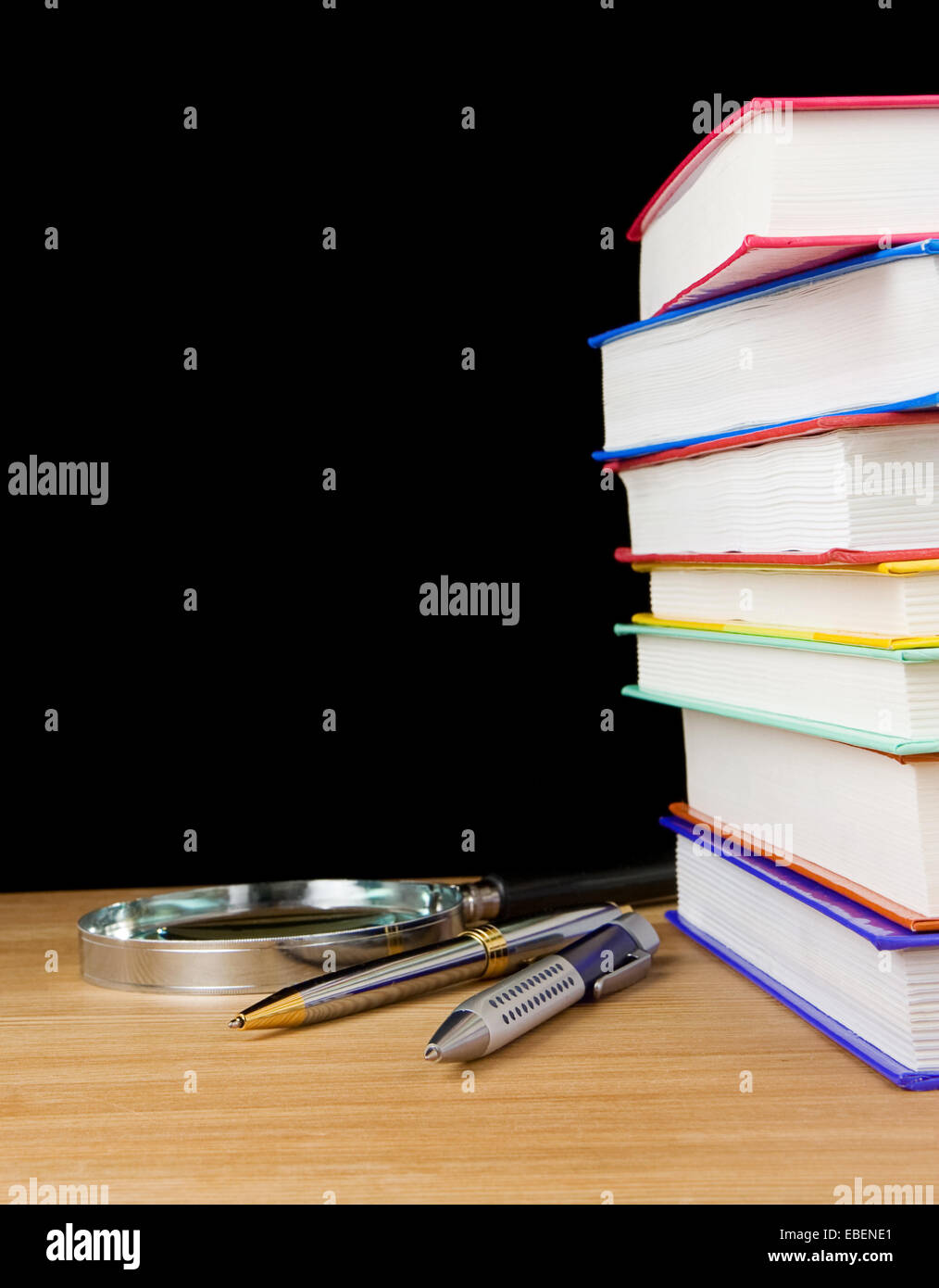 pile of books and pen on black background Stock Photo - Alamy