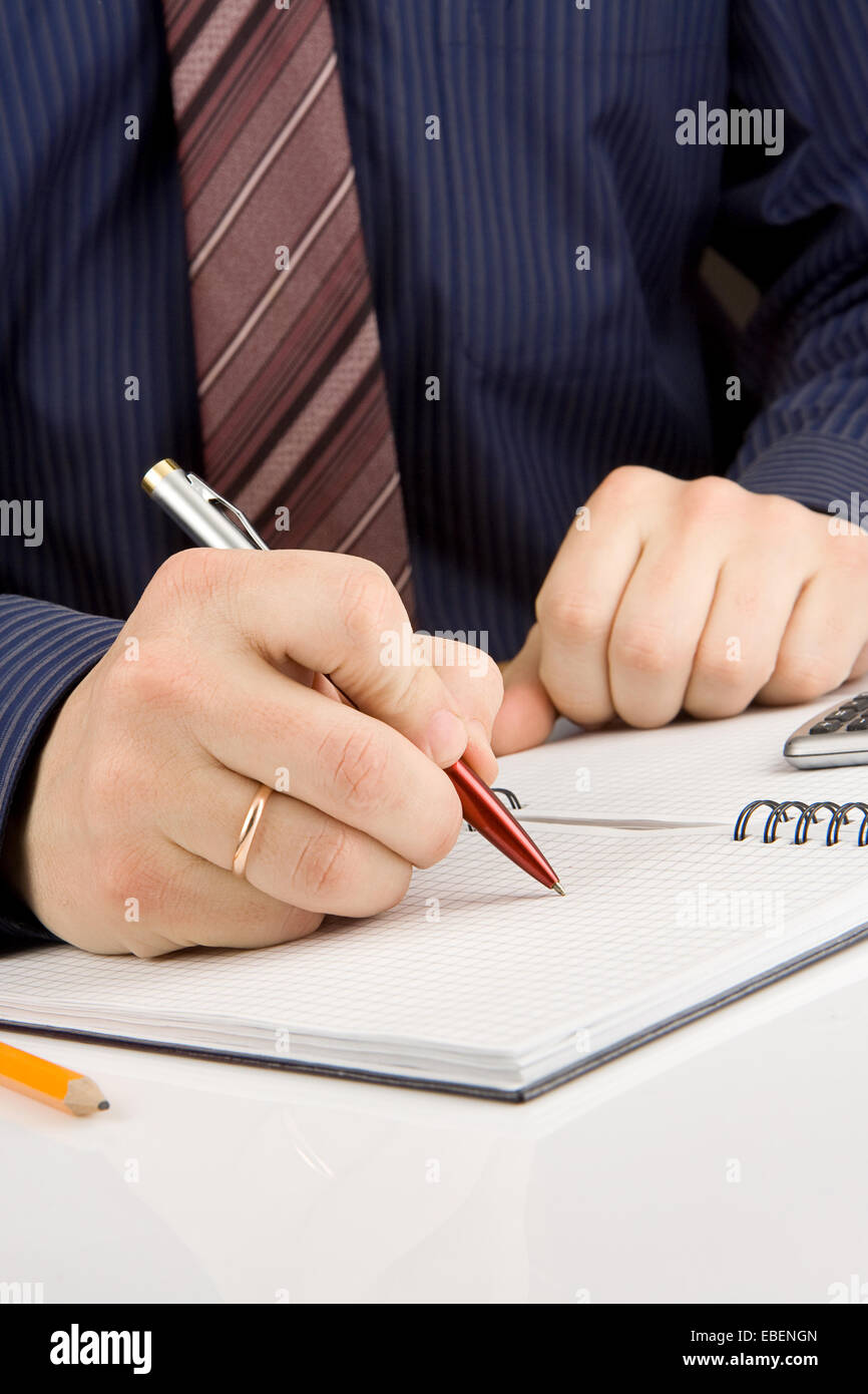 male hand writing by pen on checked notebook Stock Photo