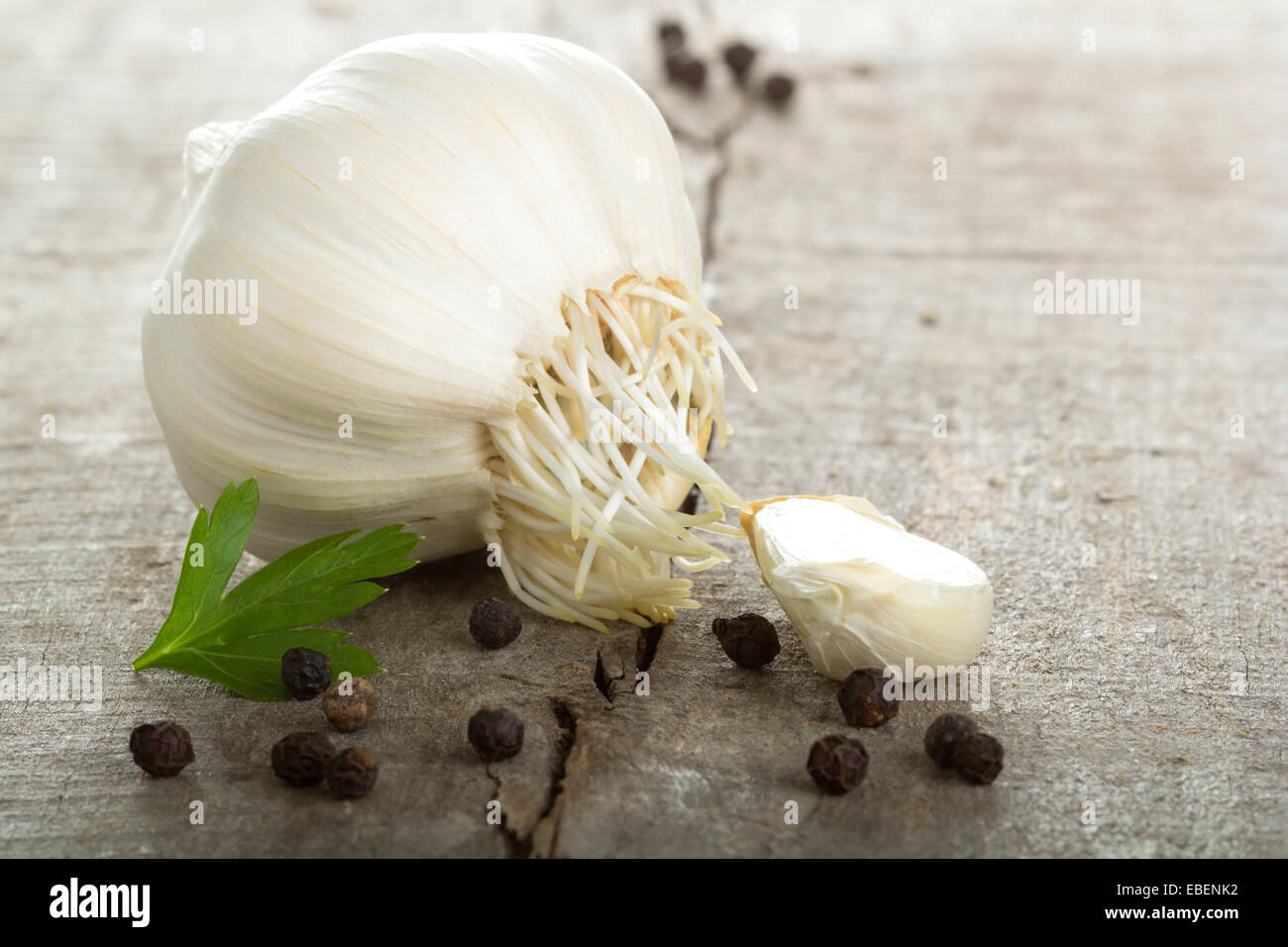 Garlic bulb, pepper and parsley over wood background Stock Photo