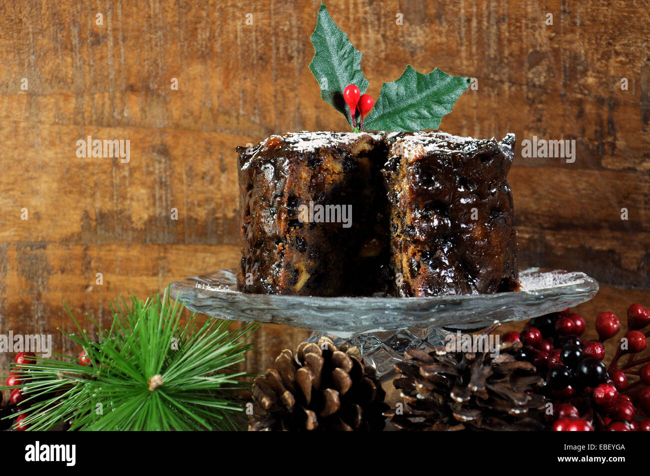 Dark spicy rich Christmas fruit cake in traditional country style wood background setting. Stock Photo