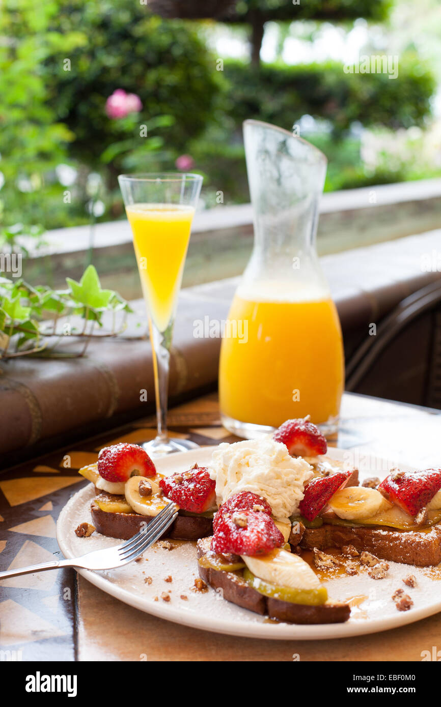 French toast and mimosa at brunch in garden patio setting Stock Photo