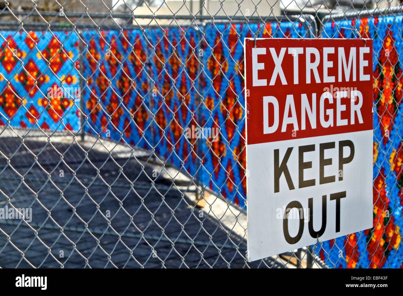 'Extreme Danger' warning juxtaposed against decorated security fencing, Christchurch rebuild post earthquake Stock Photo
