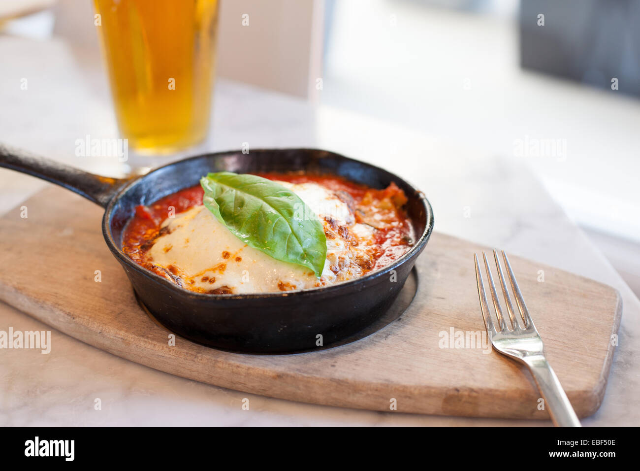 Oven baked lasagna in a cast iron skillet with beer Stock Photo