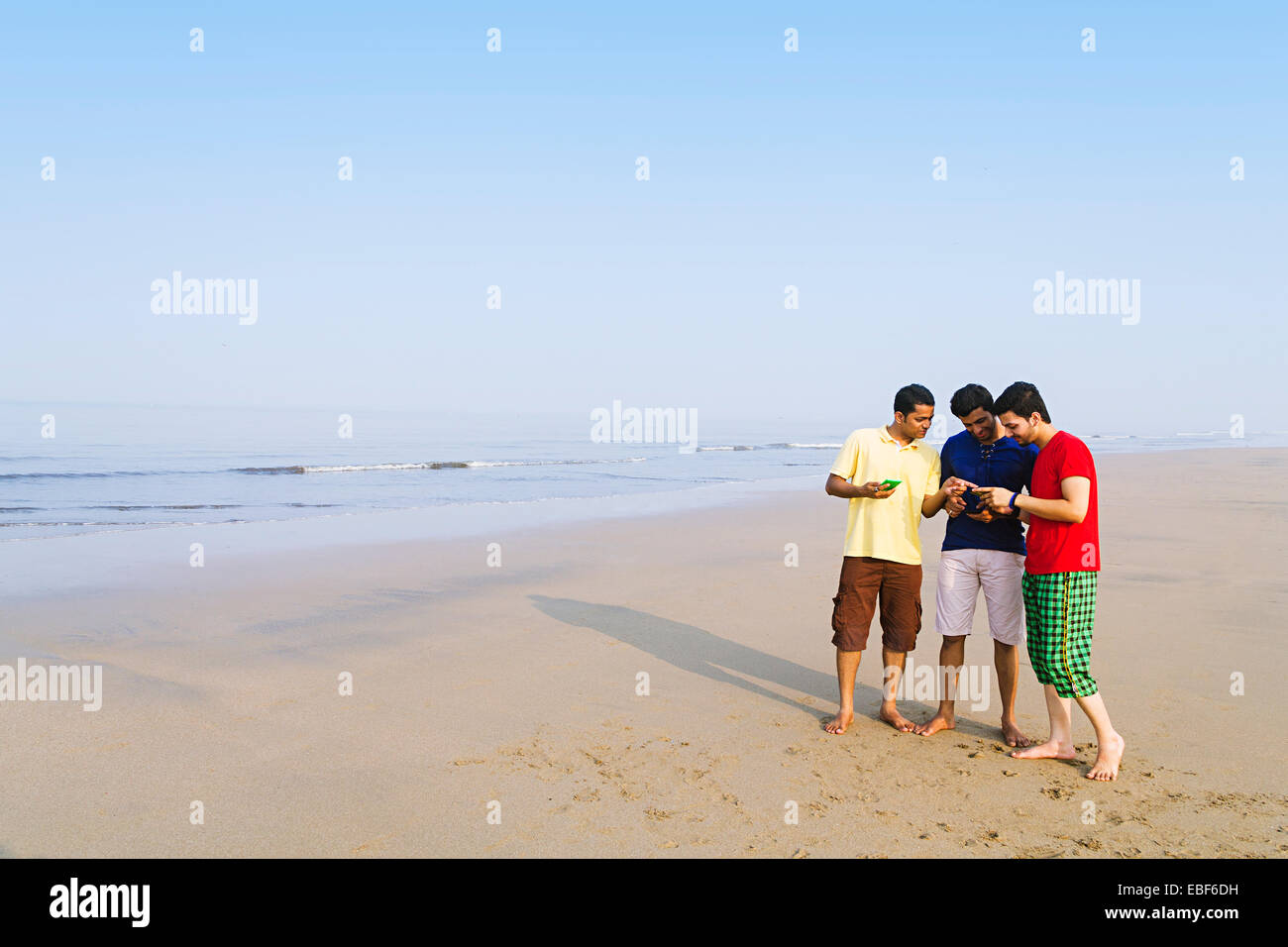 indian friends beach  Dialing  Mobile Phone Stock Photo