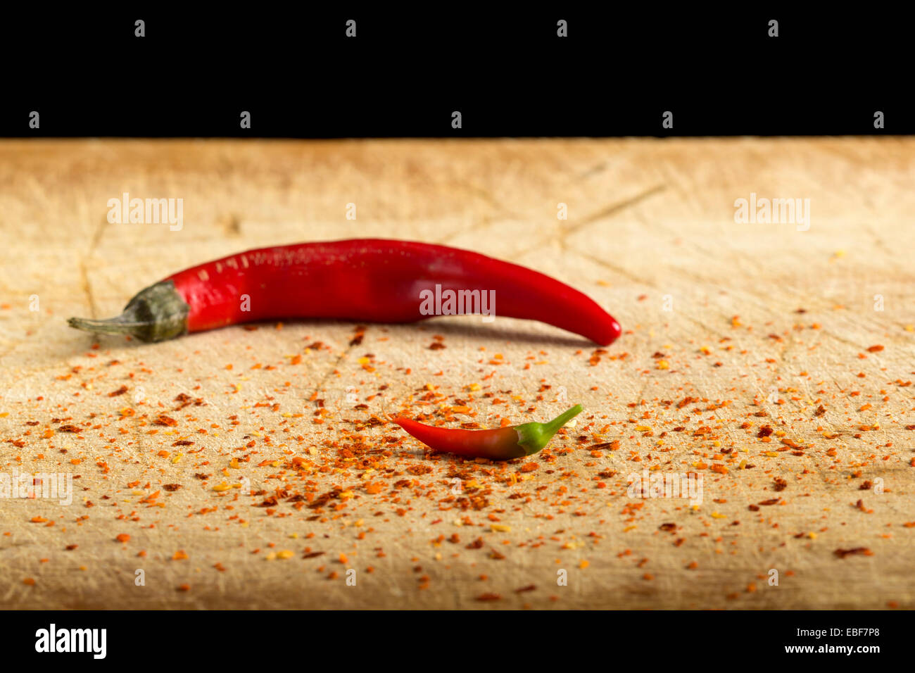 Little red hot pepper and a big hot pepper on wood Stock Photo