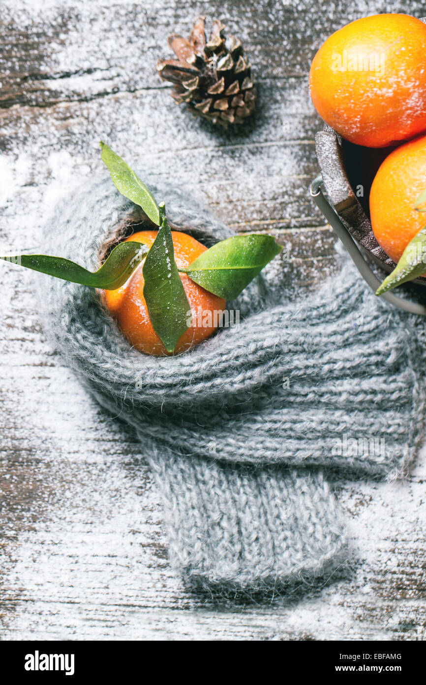 https://c8.alamy.com/comp/EBFAMG/tangerine-in-scarf-over-wooden-background-with-snow-and-cone-top-view-EBFAMG.jpg